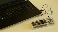 Open-source spectrophotometer connected to a laptop with sample cuvettes beside it Open-source spectrophotometer connected to a laptop with sample cuvettes beside it