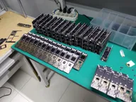 Small production batch of assembled DI-Lambda units and front panels on a workbench Small production batch of assembled DI-Lambda units and front panels on a workbench